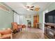 Cozy living room with wood-look floors, a ceiling fan, and plenty of natural light through the windows at 2102 W Knights Griffin Rd, Plant City, FL 33565