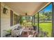 Relaxing screened-in porch with comfortable seating and plant decor overlooking the yard at 2102 W Knights Griffin Rd, Plant City, FL 33565