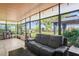Sunroom with tile floors and large windows featuring a view of the landscaped yard at 2102 W Knights Griffin Rd, Plant City, FL 33565