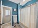 Bathroom with blue walls, shower-tub combo, a small cart and a sink and vanity at 2745 Horseshoe Dr, Plant City, FL 33566
