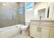 Cozy bathroom featuring a bathtub with glass doors, toilet, and vanity with white cabinets at 3012 E 149Th Ave, Lutz, FL 33559