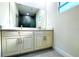 Bathroom with a large mirror, double vanity with white cabinets and stone countertop at 3012 E 149Th Ave, Lutz, FL 33559