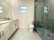 Bright bathroom featuring a modern sink, toilet, and glass-enclosed shower with stylish stone pebble floor at 3012 E 149Th Ave, Lutz, FL 33559