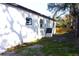 Exterior view with gray trim, white siding, updated windows, and large trees at 3012 E 149Th Ave, Lutz, FL 33559