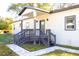 Charming front entrance with a welcoming porch, gray trim, and well-maintained landscaping at 3012 E 149Th Ave, Lutz, FL 33559