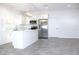 This is a kitchen with white cabinets, a large island, modern lighting and stainless steel appliances at 3012 E 149Th Ave, Lutz, FL 33559