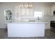 An open kitchen features custom cabinets, an island with a quartz countertop and stainless steel appliances at 3012 E 149Th Ave, Lutz, FL 33559