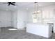This is a kitchen with white cabinets, a large island, modern lighting and stainless steel appliances at 3012 E 149Th Ave, Lutz, FL 33559
