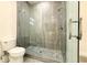 Modern shower with glass doors, grey tiling, and sleek fixtures at 3012 E 149Th Ave, Lutz, FL 33559