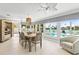 Bright dining room with pool view, light wood floors, pendant lighting, and seating for six at 3102 W Vina Del Mar Blvd, St Pete Beach, FL 33706