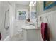 Bright bathroom featuring a pedestal sink, tub-shower, and white paneling at 3235 8Th N Ave, St Petersburg, FL 33713