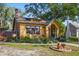 Quaint yellow home featuring a brick chimney, well-manicured lawn, and arched front porch at 3235 8Th N Ave, St Petersburg, FL 33713