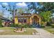 Quaint yellow home featuring a brick chimney, well-manicured lawn, and arched front porch at 3235 8Th N Ave, St Petersburg, FL 33713