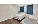 This bedroom features hardwood floors, a queen sized bed, a nightstand, and blue curtains at 4221 W Spruce St # 1123, Tampa, FL 33607