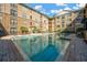 Community pool with lots of lounge chairs surrounded by apartments and palm trees at 4221 W Spruce St # 1123, Tampa, FL 33607