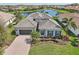 An aerial view of the house highlights its landscaping and surroundings, including a nearby pond at 4857 Tobermory Way, Bradenton, FL 34211