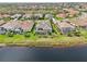 An aerial view shows homes with backyards, screened patios and pools bordering a lake at 4857 Tobermory Way, Bradenton, FL 34211