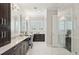 Elegant bathroom with dark wood cabinets, marble countertop, double sinks, and walk-in shower at 4857 Tobermory Way, Bradenton, FL 34211