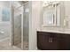 Well-lit bathroom features walk-in shower with neutral tile, a dark wood vanity and a bright white countertop at 4857 Tobermory Way, Bradenton, FL 34211