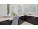 Elegant bathroom vanity with dark wood cabinets, marble countertop and decorative chair at 4857 Tobermory Way, Bradenton, FL 34211