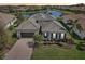 Beautiful single-story home with tile roof, lush landscaping, brick paver driveway, and picturesque water view at 4857 Tobermory Way, Bradenton, FL 34211