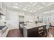 Bright kitchen area with a large granite island, coffered ceilings, and stainless steel appliances at 4857 Tobermory Way, Bradenton, FL 34211
