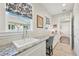 Inviting laundry room featuring granite countertops, sink, tile backsplash, and sunlit windows with stylish patterned shades at 4857 Tobermory Way, Bradenton, FL 34211