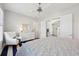 Bright main bedroom with bed, dresser, and comfy chair has a modern design and ceiling fan at 4857 Tobermory Way, Bradenton, FL 34211