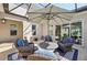 Inviting outdoor seating area with umbrella, wicker furniture, blue cushions, and view through the sliding glass doors at 4857 Tobermory Way, Bradenton, FL 34211