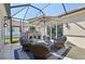 Beautiful screened-in patio featuring a cozy seating area with umbrella and fireplace at 4857 Tobermory Way, Bradenton, FL 34211