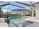 Inviting screened pool area featuring a sun umbrella, offering a perfect spot to relax and enjoy the outdoors at 4857 Tobermory Way, Bradenton, FL 34211