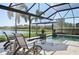 Serene pool area with relaxing lounge chairs overlooking a tranquil lake, all within a screened enclosure at 4857 Tobermory Way, Bradenton, FL 34211
