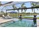 Sparkling pool with screened enclosure, waterfront views, lounge chairs and tropical landscaping at 4857 Tobermory Way, Bradenton, FL 34211