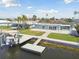 Aerial view of light blue home with a boat lift and a dock, plus a well-manicured lawn at 5321 Bowline Bnd, New Port Richey, FL 34652