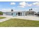 The backyard features a spacious patio, green lawn, and sliding glass doors to the light blue house at 5321 Bowline Bnd, New Port Richey, FL 34652