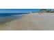 Calm beach view with shallow, clear water and gentle waves meeting the sandy shoreline at 5321 Bowline Bnd, New Port Richey, FL 34652