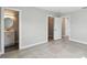 Bedroom showcasing neutral tones, gray tile floors, and adjacent bathroom and closet at 5321 Bowline Bnd, New Port Richey, FL 34652