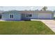 Well-maintained single-story home with lush green lawn, a two-car garage, and a paved driveway and walkway at 5321 Bowline Bnd, New Port Richey, FL 34652