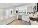 Modern kitchen with white cabinets, marble countertops, stainless steel appliances, and a pass-through window at 5321 Bowline Bnd, New Port Richey, FL 34652