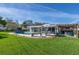 Inviting backyard with a swimming pool, patio furniture, pergola, and lush green lawn for relaxation and entertainment at 553 E Lake Dr, Largo, FL 33771