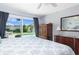 Light-filled bedroom with a pool view through sliding glass doors and classic wooden furniture at 553 E Lake Dr, Largo, FL 33771