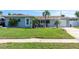 Well-kept single-story home with a green lawn, driveway, and a cozy, covered front porch area at 553 E Lake Dr, Largo, FL 33771