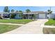 Charming single-story home featuring a well-manicured lawn, attached garage, and a welcoming covered entryway at 553 E Lake Dr, Largo, FL 33771