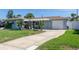 Charming single-story home featuring a well-manicured lawn, attached garage, and a welcoming covered entryway at 553 E Lake Dr, Largo, FL 33771