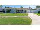 Well-kept single-story home with a green lawn, driveway, and a cozy, covered front porch area at 553 E Lake Dr, Largo, FL 33771