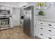 Modern kitchen with stainless steel appliances, white cabinets, and tile flooring at 553 E Lake Dr, Largo, FL 33771