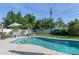 Inviting pool area with a patio, outdoor seating, and well-maintained landscaping perfect for relaxation and entertainment at 553 E Lake Dr, Largo, FL 33771