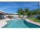 Inviting pool with clear blue water, surrounded by a patio with an umbrella and lush green landscaping at 553 E Lake Dr, Largo, FL 33771