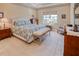 Comfortable bedroom with neutral tones, accent chair, and a window providing ample natural light at 6104 Talon Preserve Dr, Nokomis, FL 34275