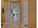 Inviting hallway with wood-look tile flooring, leading to various rooms with neutral-toned walls and detailed trim at 6104 Talon Preserve Dr, Nokomis, FL 34275